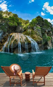 Travel to Provence. Two chairs and a straw hat in front of a waterfall on the river Verdon