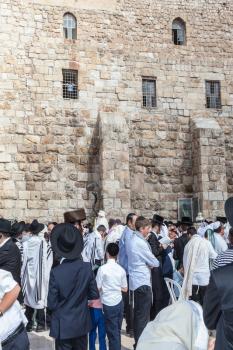 JERUSALEM, ISRAEL - OCTOBER 12, 2014: Crowd of faithful Jews wearing prayer shawls. Morning autumn Sukkot. The area in front of Western Wall of  Temple filled with people