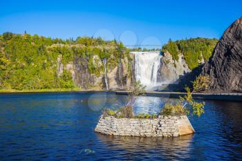 Montmorency Falls Park, in Quebec.  Small picturesque artificial island on the lake. Above the waterfall built bridge for walking. The concept of active and cultural tourism