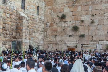 JERUSALEM, ISRAEL - OCTOBER 12, 2014:  Morning autumn Sukkot. Crowd of Jewish worshipers in white wearing prayer shawls. The area of Western Wall of  Temple filled with people