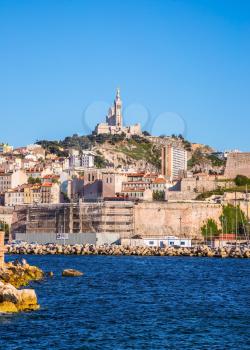 Marseilles. The water area of the Old Port - speedboats, yachts and fishing boats. On the hill - splendid Basilica of Notre-Dame de la Garde