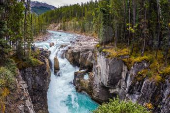  Autumn trip to Canada, Jasper National Park. The picturesque waterfall Sanvapta Falls. The concept of extreme and ecological tourism