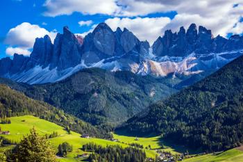 Odle mountain peaks surround the green alpine meadows of the valley. Dolomites, Val de Funes valley. Lovely sunny day in  Nature Park Puez-Odle