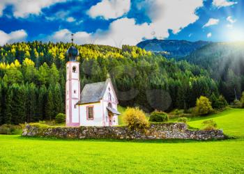 The summer sunset, Dolomites, Tirol. The famous church of St. Mary Magdalene and bell tower in a mountain valley. The concept of eco-tourism 
