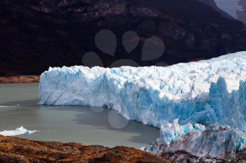 The fantastic glacier Perito Moreno, in the lake Argentine, Patagonia. The glacier shine with reflected sunlight. The concept of exotic and extreme tourism
