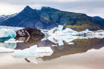 The largest glacier in Iceland - Vatnajokull. Huge ice floes have broken away from a glacier and drift towards the ocean. The concept of northern extreme tourism