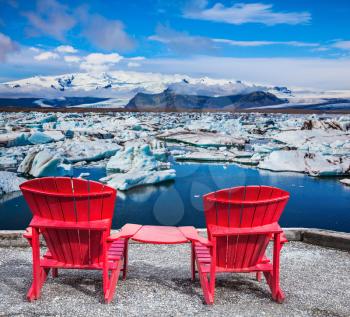 Two red deck chairs for admiring drift ice - Jokulsarlon. The concept of extreme northern tourism in Ice Lagoon, Iceland