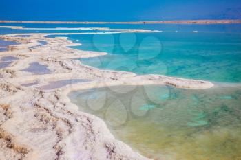 Hot summer day at the seaside resort. Walk on the Dead Sea, Israel. The evaporated salt has developed into fantastic patterns. The concept of medical and ecological tourism 