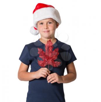 Handsome boy in the red hat of Santa Claus posing with decoration for Christmas tree - maple leaf.  Photographed on a white background