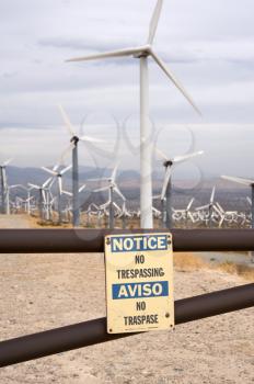 Royalty Free Photo of a Wind Turbine Farm With a Notice of No Trespassing