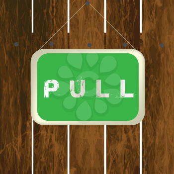 Pull sign hanging on a wooden fence