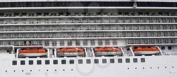 Side view of a cruise ship with lifeboats and cabins balcony