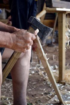 Wood worker carving in wood with an ax