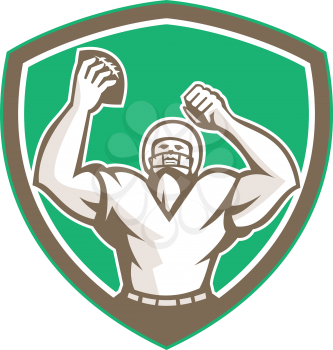Illustration of an american football with helmet holding ball over head celebrating viewed from the front set inside shield crest on isolated background done in retro style. 
