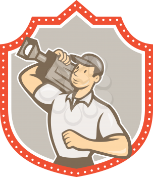 Illustration of a cameraman movie director holding vintage movie film camera on shoulder set inside shield crest on isolated background viewed from side done in cartoon style.