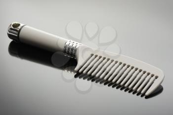 Royalty Free Photo of a Grey Comb on a Grey Background