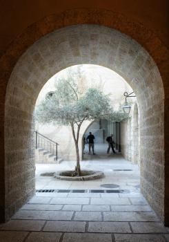 Royalty Free Photo of Fragments of the Old City of Jerusalem, a Street with an Arch and Courtyard With a Tree.