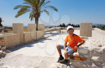 Royalty Free Photo of a Boy on the Remains of Settlements on the Hill Megiddo 