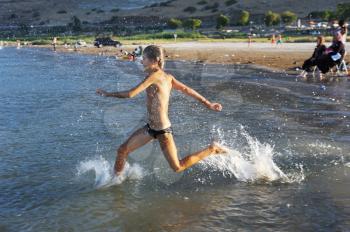 Royalty Free Photo of a Boy Running in Lake Water