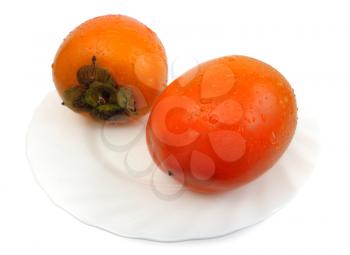 Persimmon on a white plate on a white background, isolated
