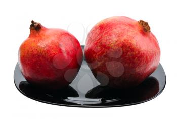 Pomegranate on a black platte on white background, isolated.