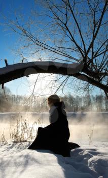Royalty Free Photo of a Person Sitting at the River in Winter