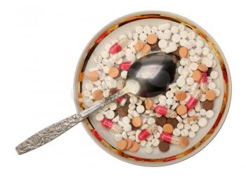 Several white, red and brown pills on the saucer, isolated