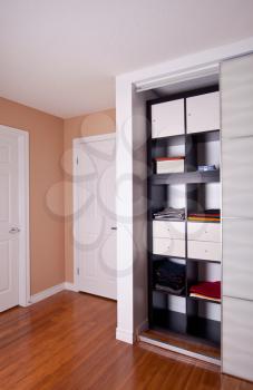 Built-in closet with sliding door shelving storage organization solution filled with clothes