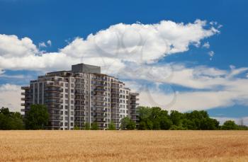 Modern residential high rise building in the middle of grain field landscape view