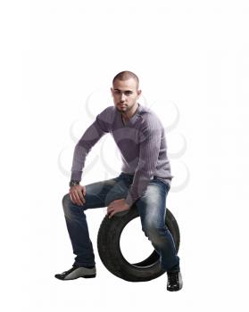 young latin male and car tyre isolated on the white background