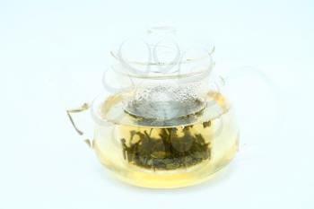 Teapot with green tea on gray background