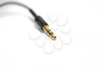 Macro of audio cable isolated on white background with gold connector (jack)