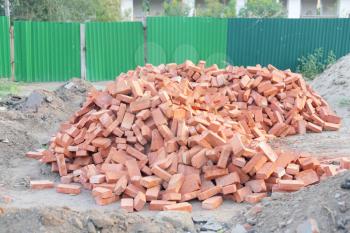 Lots of new red clay bricks lying outdoors