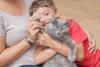 mother and son with gray cat having fun indoors