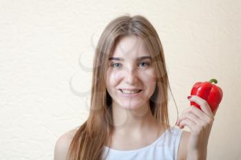 beautiful girl with red sweet pepper head and shoulders shot - organic food and health concept