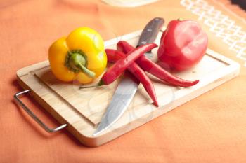 Red peppers on wood with knife (chilli sliced)
