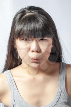 portrait of a lovely young asian woman studio on white headshot making face