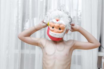 Cheerful boy in Santa Claus Mask, new year, indoors