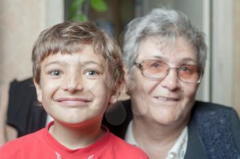 portrait of a senior woman and her grandson indoors