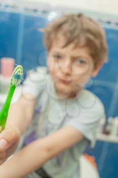 kid brushing teeth in a bathroom.