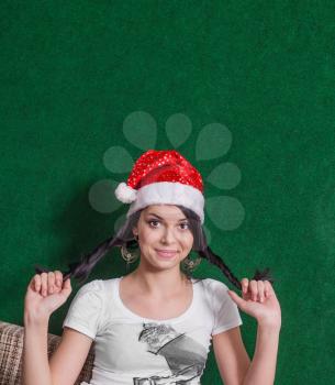 happy mrs. Santa indoors, cute brunette smiling and looking at camera on green background