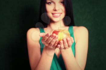 Front view of the 20s female holding an apple in her hands, focus on the apple