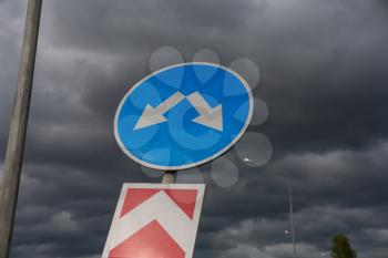 Road sign against cloudy sky