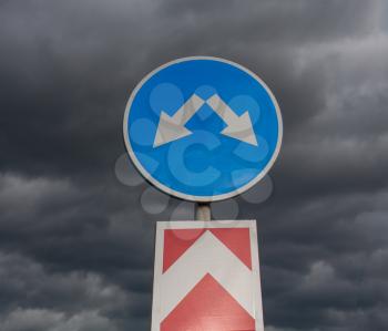 Road sign against cloudy sky square image