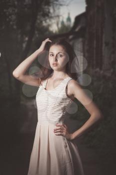 Beautiful urban woman, girl in dress in the old street. Old aged photo stylization