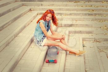 Redhead women sitting on street stairs hear her skate board instagram style colors image