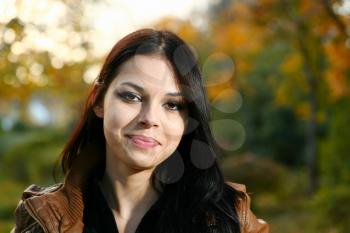 Autumn outdoor portrait of beautiful Latina American young woman head and shoulders front view