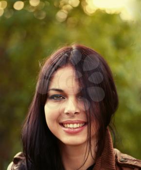 Casual woman headshot in autumn park smiling