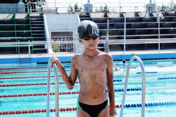 Small boy posing in swimming pool