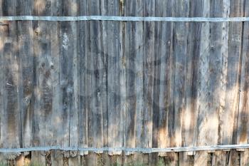 old wooden fence in garden made of obsolete planks